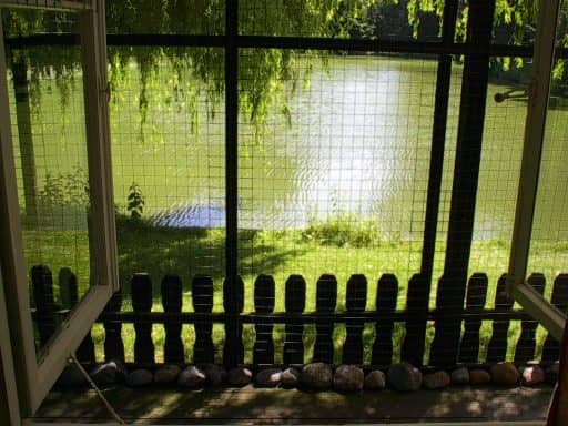 Haus 2, Außenbereich 1: Gitterwand mit Blick auf Rasen und Bäume